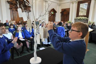 Schoolchildren place cards on the ‘Tree of Life.’