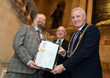 Cllr Paul Dean presents the award to the Mayor, Cllr John McCabe, while Joe Mills from NAAFI Break looks on.